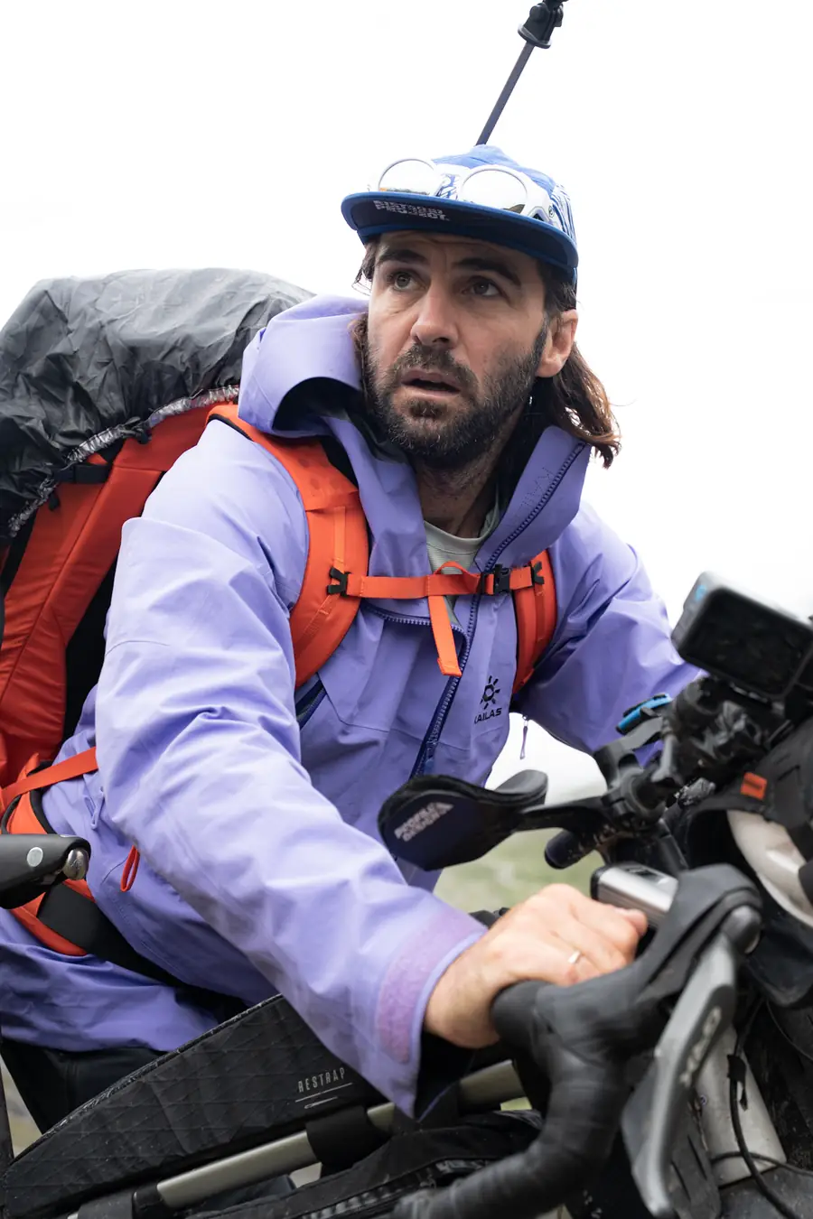Steven Le Hyaric penché sur son cintre, sac d'alpinisme sur le dos