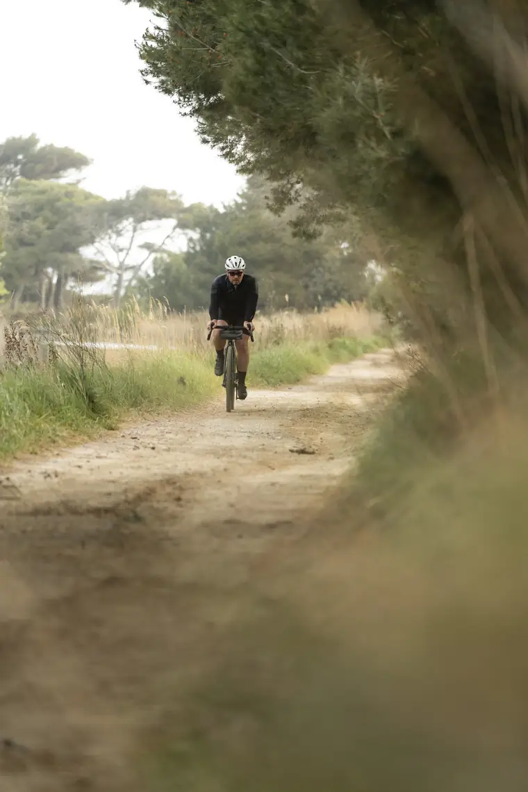 Un participant remonte une piste blanche entre les herbes hautes